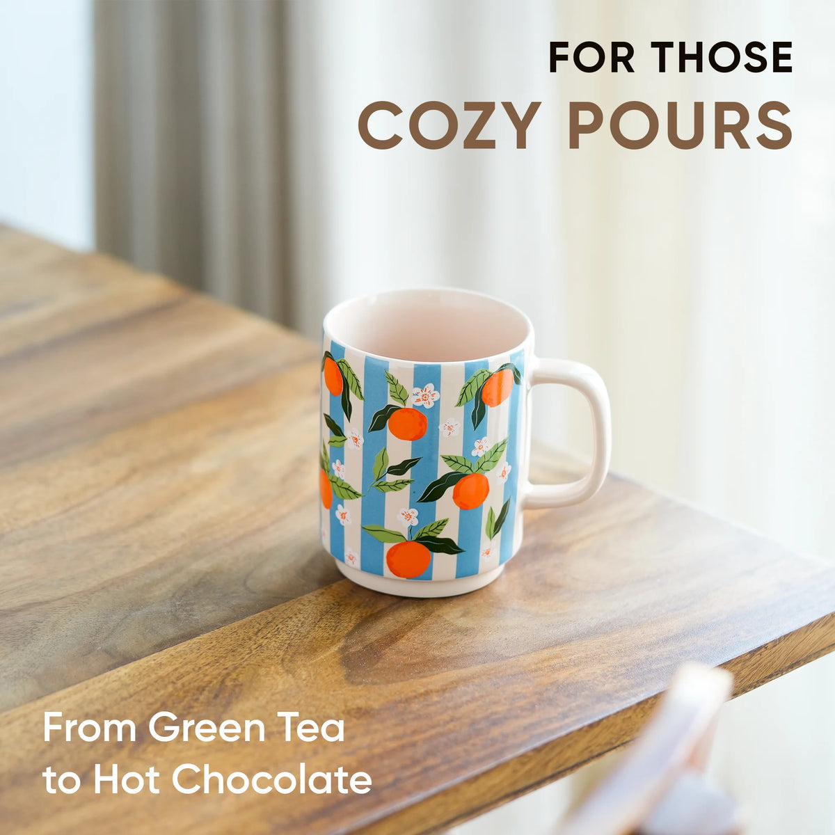 Mug with floral design on a wooden table, text 'For those cozy pours' and 'From Green Tea to Hot Chocolate'.