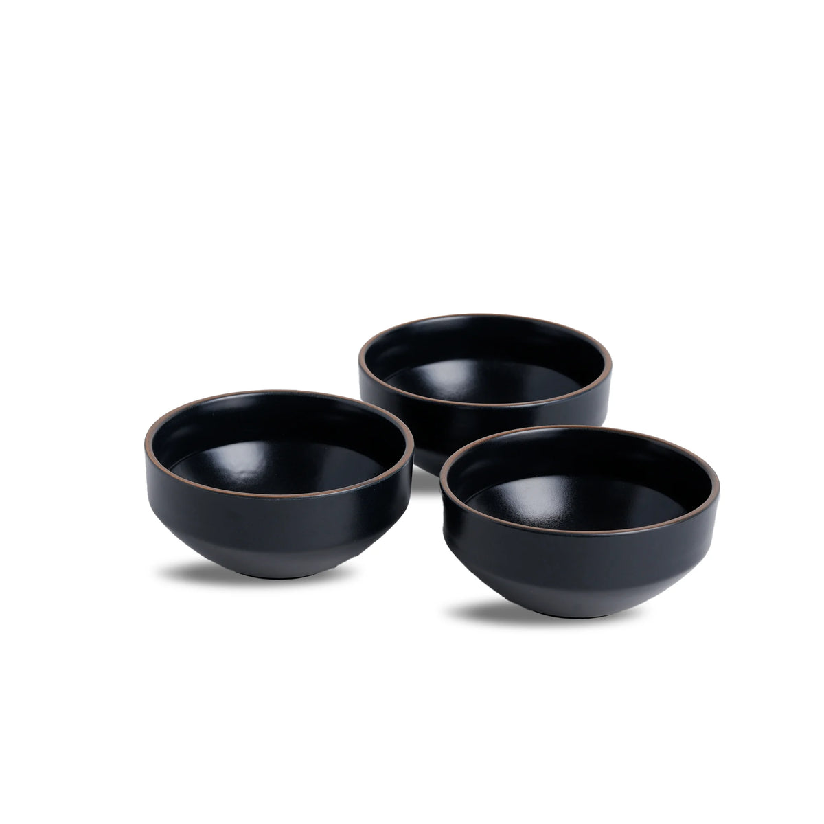 Three black ceramic bowls on a white background
