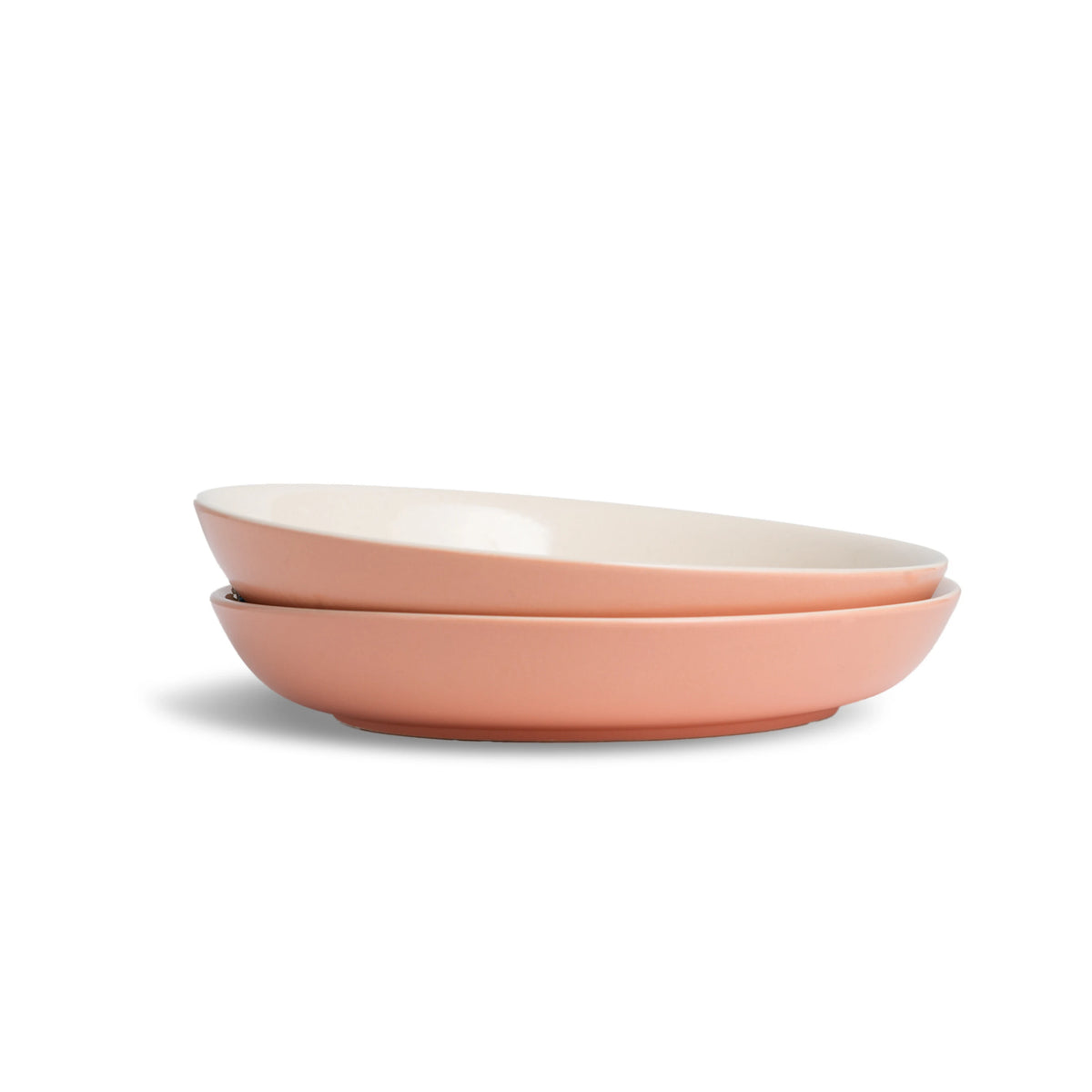 Two pink ceramic bowls stacked on a white background