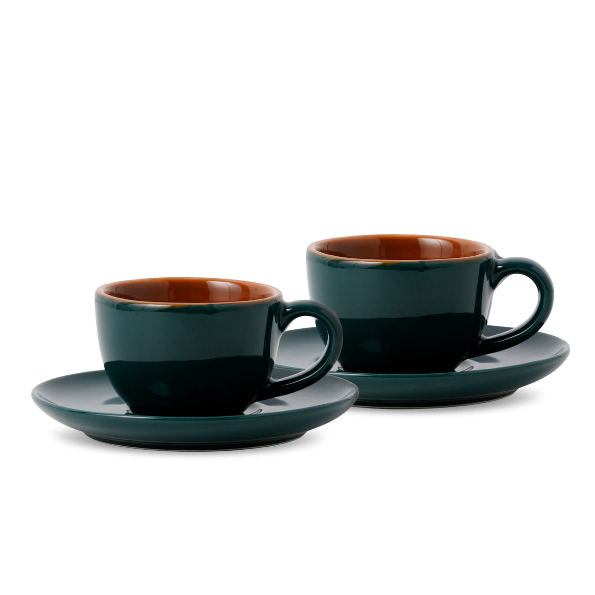 Two dark green espresso cups with brown interiors on white background