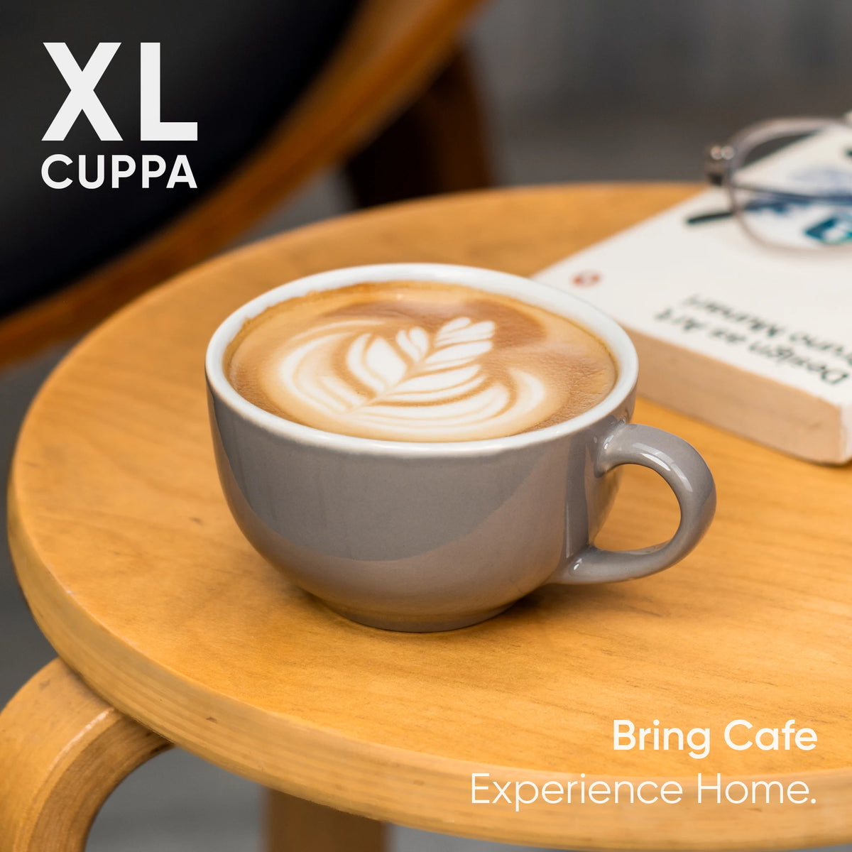 Cappuccino in a gray mug on a wooden table with 'XL Cuppa' branding.