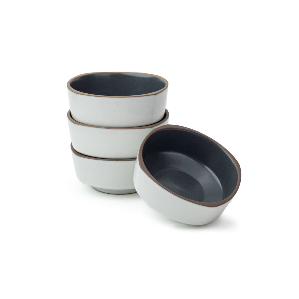 Set of four ceramic bowls with gray interior and white exterior on a white background