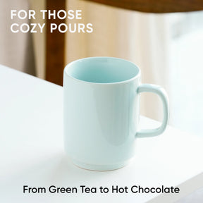 Light blue mug on a white surface with text about cozy pours and drink options.