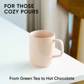 Beige mug on a white surface with text about cozy pours and drink options.