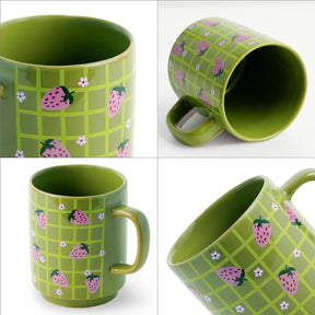 Green mug with strawberry pattern on a white background