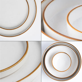 Set of white plates with gold rims arranged in a grid pattern.