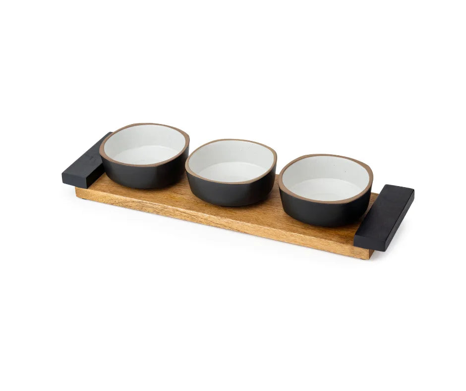 Set of three black and white ceramic bowls on a wooden tray with black holders.