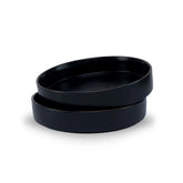 Two black ceramic bowls stacked on a white background