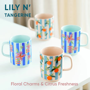 Set of colorful mugs with floral and tangerine designs on a white surface.
