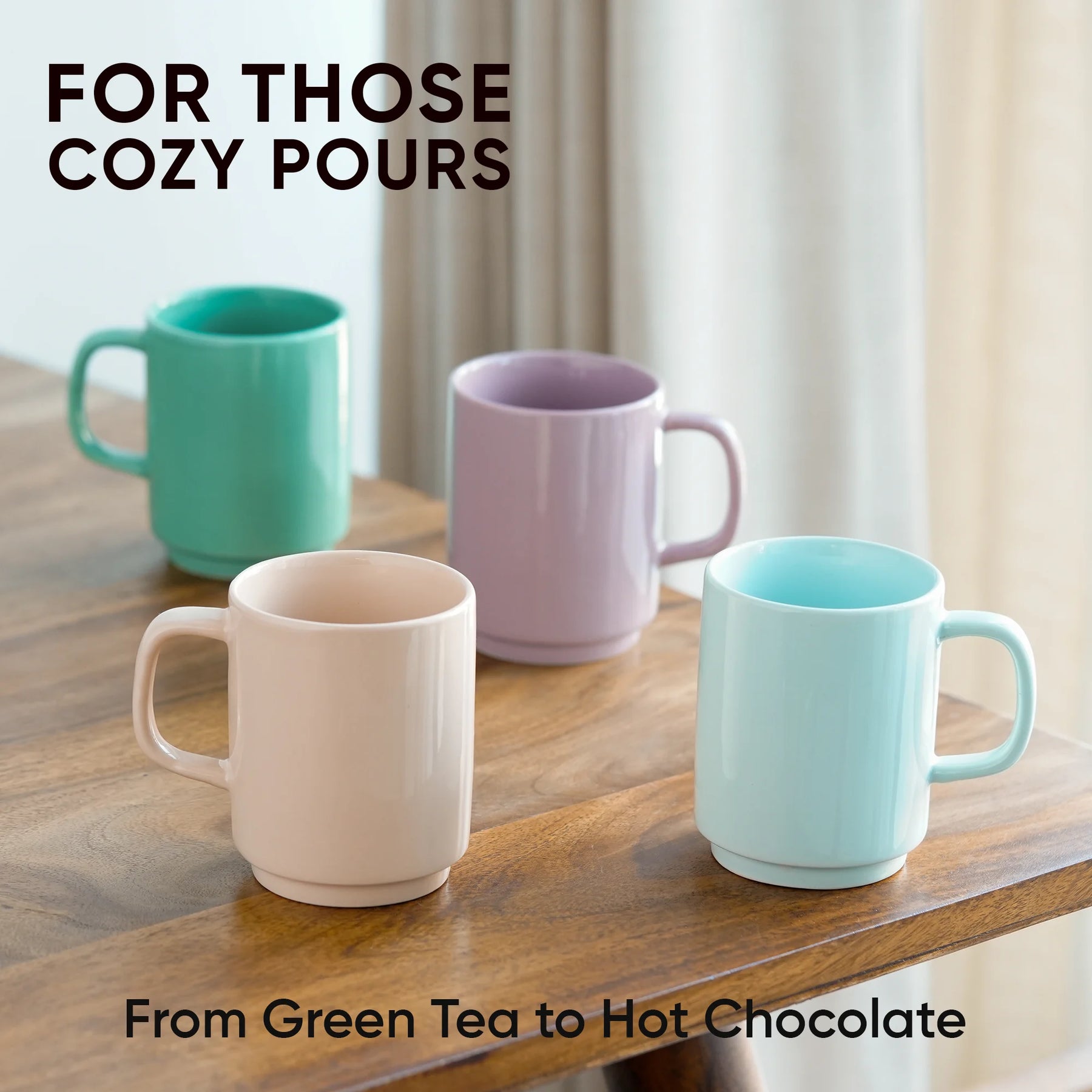 Four colorful mugs on a wooden surface with text about cozy pours.