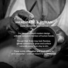 Person holding a ceramic piece with text about handmade ceramics.