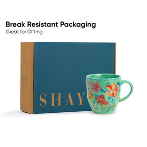 Floral mug with 'SHAY' branding next to a blue box labeled 'SHAY', with text 'Break Resistant Packaging Great for Gifting'.