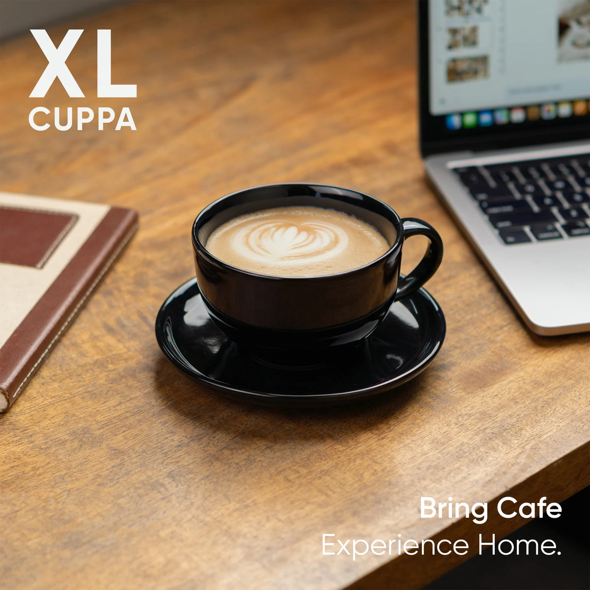 Black coffee cup with saucer on a wooden table next to a laptop, with 'XL Cuppa' branding.