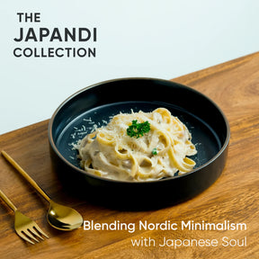 Pasta dish in a black bowl on a wooden table with 'Japandi Collection' text.