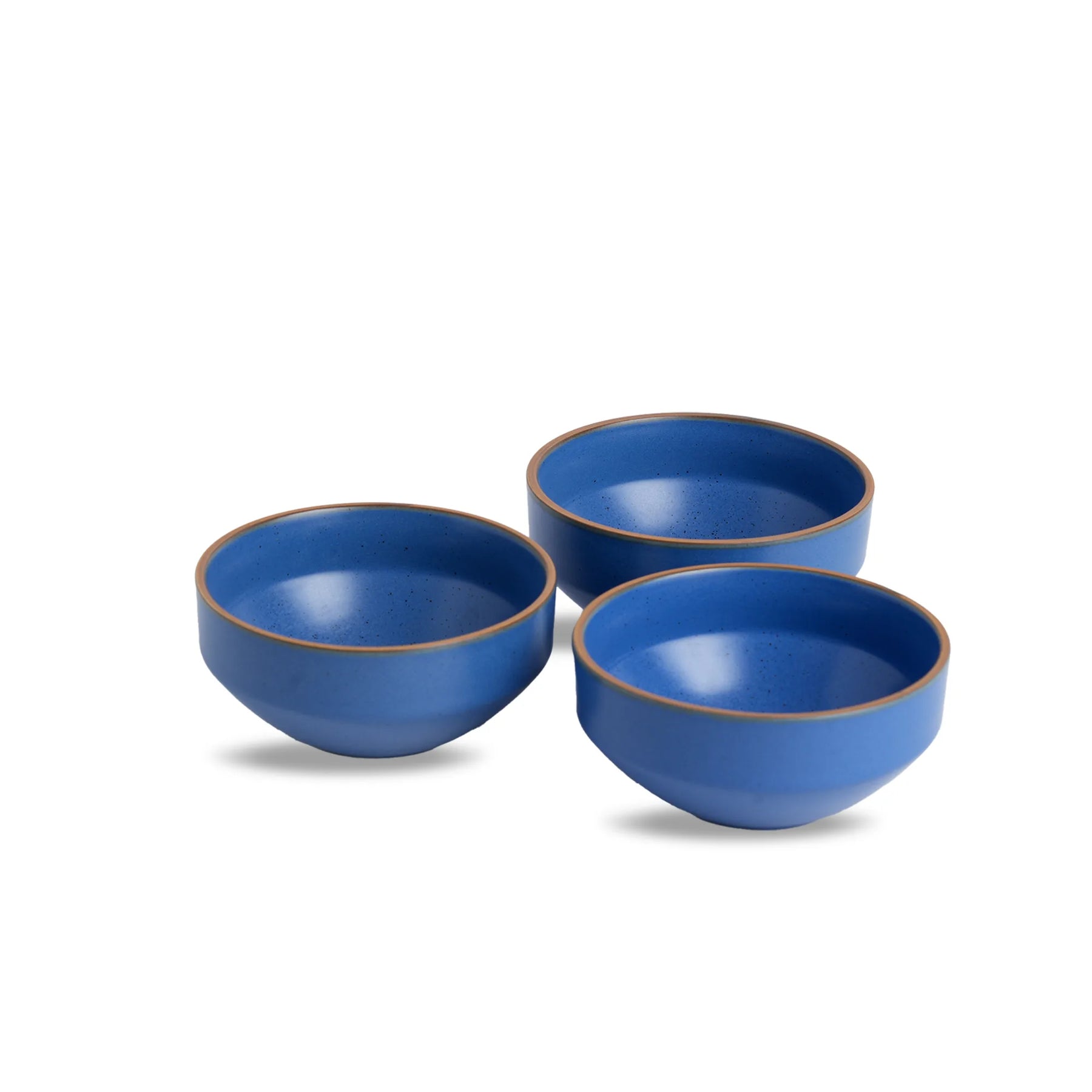 Three blue ceramic bowls with brown rims on a white background
