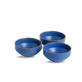 Three blue ceramic bowls with brown rims on a white background