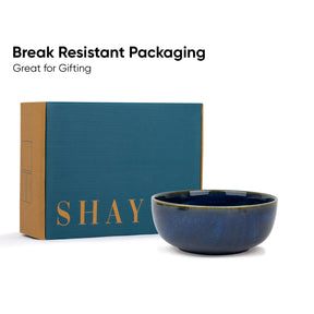 Blue ceramic bowl with 'SHAY' branding next to a teal box on a white background.