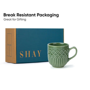 Green mug with 'SHAY' branded box on a white background