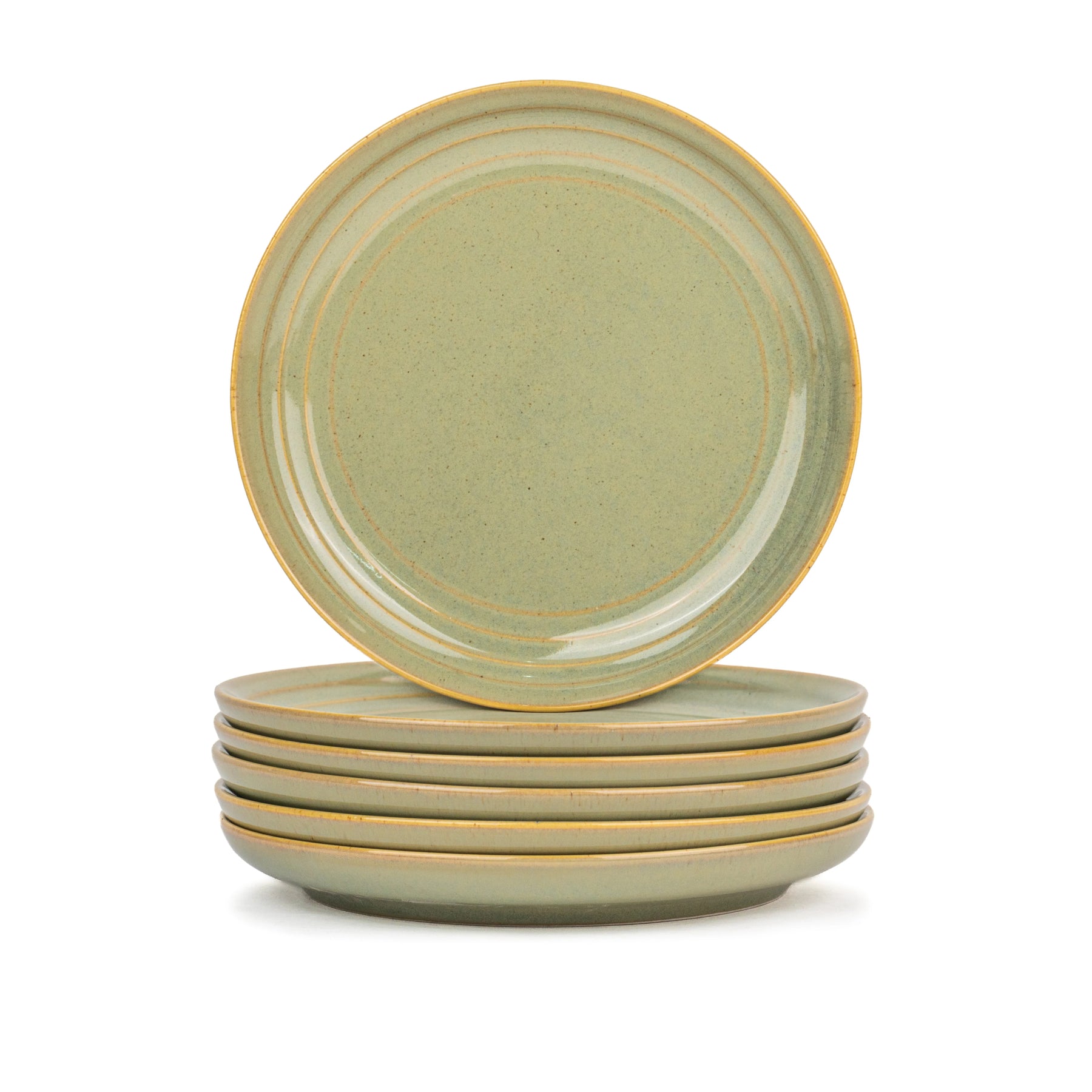 Set of four green ceramic plates stacked on a white background
