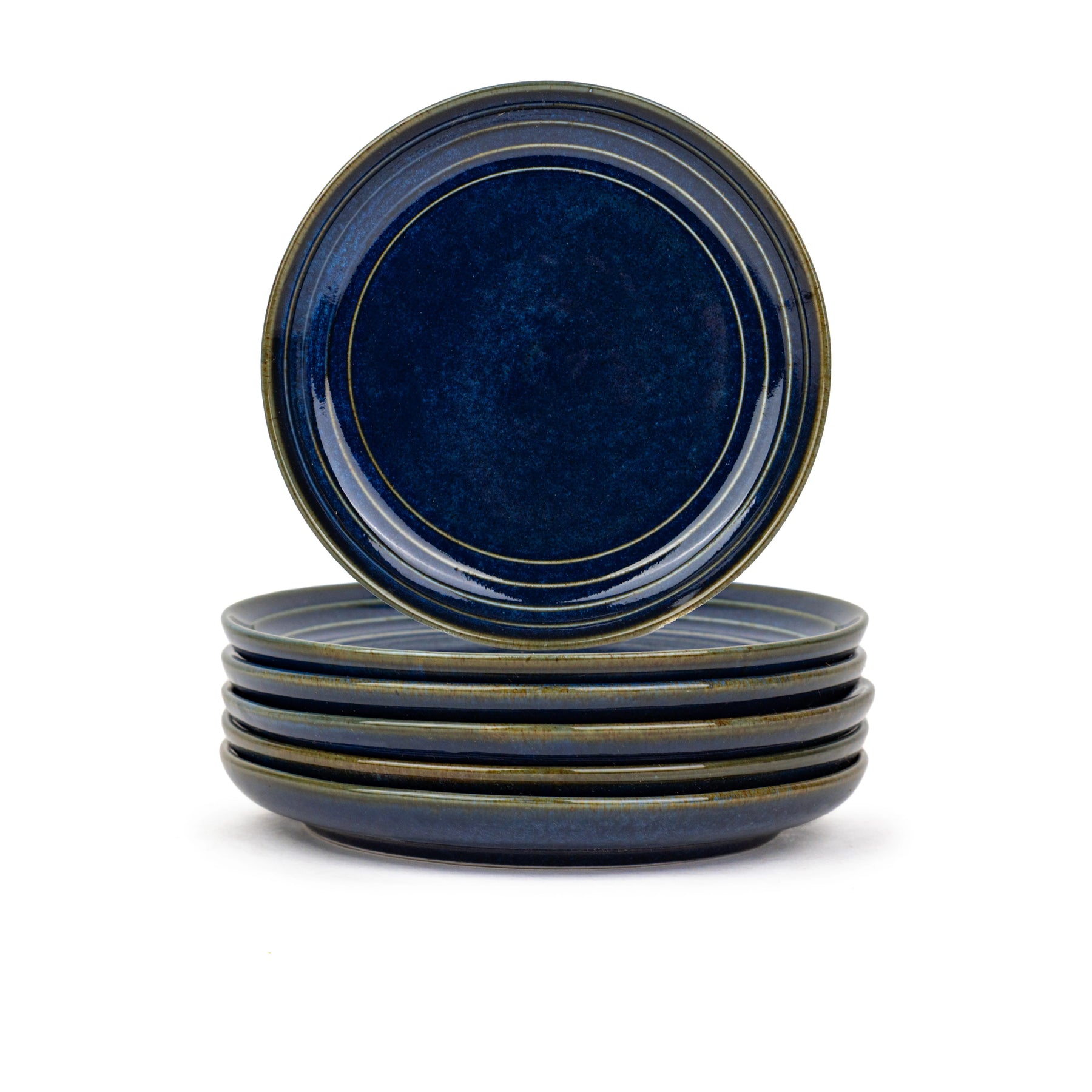 Set of four blue ceramic plates with a dark rim on a white background
