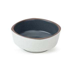 Ceramic bowl with blue interior and white exterior on a white background