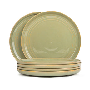 Set of four green ceramic plates on a white background