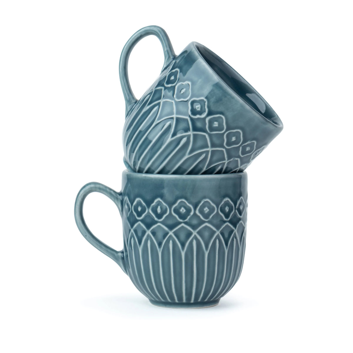 Two blue ceramic mugs with decorative patterns stacked on a white background