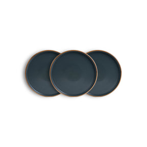 Three dark blue plates with bronze rims on a white background