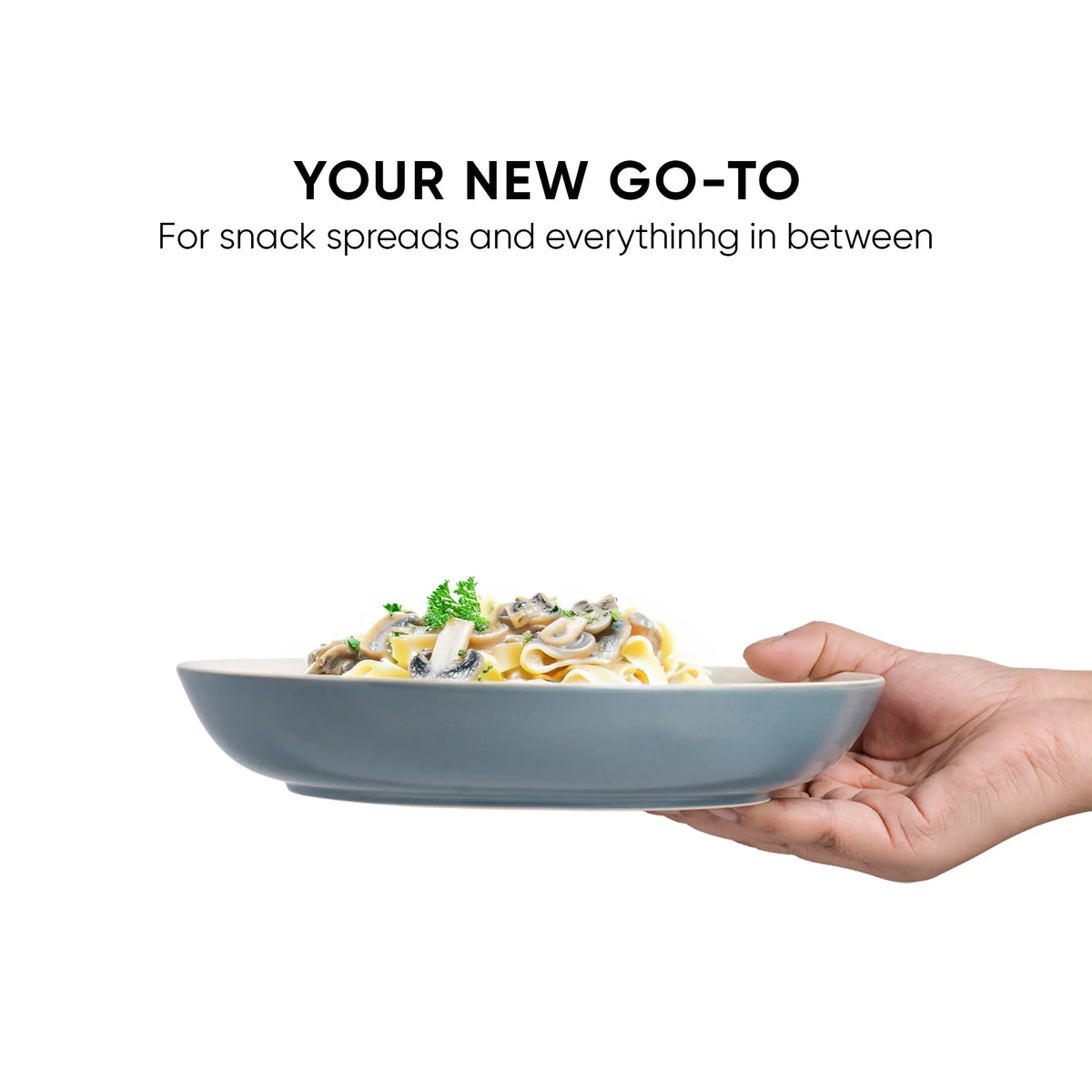 Hand holding a gray bowl with salad on a white background, text 'Your New Go-To' displayed.