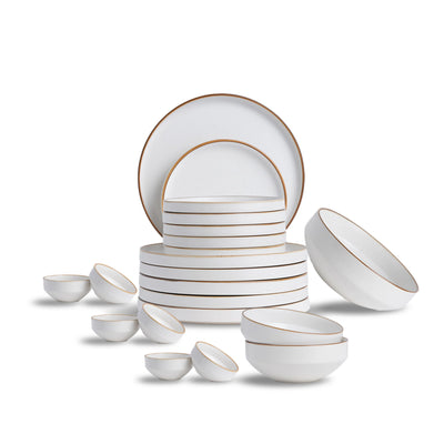 White ceramic dinnerware set with gold rims on a white background