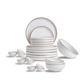 White ceramic dinnerware set with gold rims on a white background