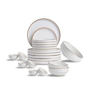 White ceramic dinnerware set with gold rims on a white background