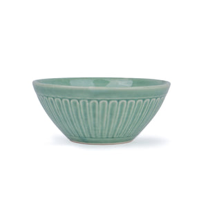Green ceramic bowl with ribbed texture on a white background