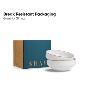 Two white bowls with gold rims in front of a blue box labeled 'SHAY' on a white background.