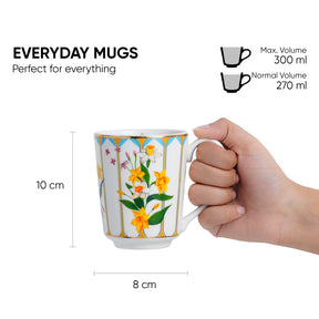 Hand holding a floral mug with measurements and product details on a white background