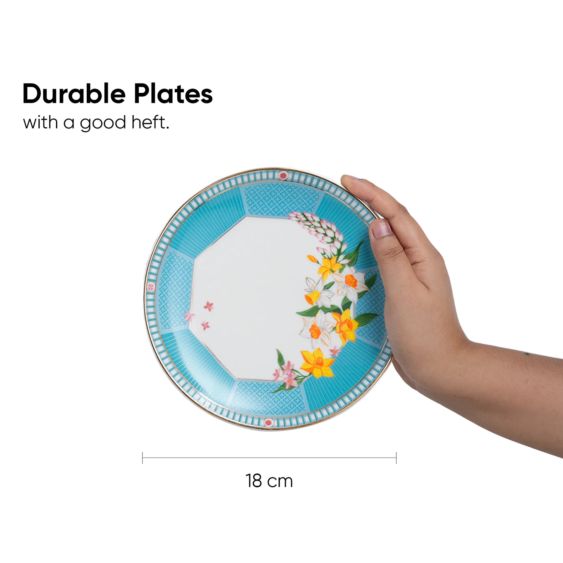 Hand holding a decorative plate with floral design, text indicating durability and size.