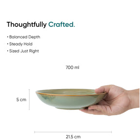 Hand holding a green ceramic bowl with dimensions and text about its features on a white background.