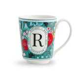 Decorative mug with floral patterns and a central 'R' on a white background