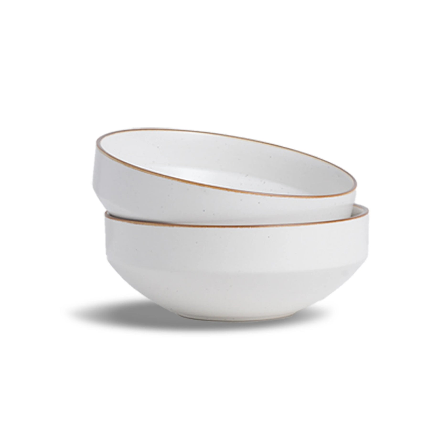 Two white ceramic bowls with gold rims stacked on a white background