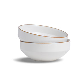 Two white ceramic bowls with gold rims stacked on a white background