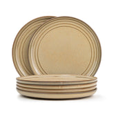 Set of beige ceramic plates with a subtle pattern on a white background