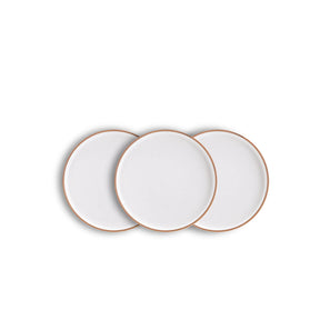 Three white plates with gold rims on a white background