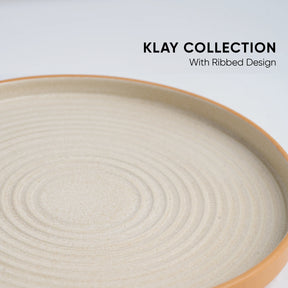 Beige ceramic plate with ribbed design on a light gray background, featuring 'Klay Collection' text.