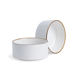 Two white ceramic bowls with gold rims on a white background