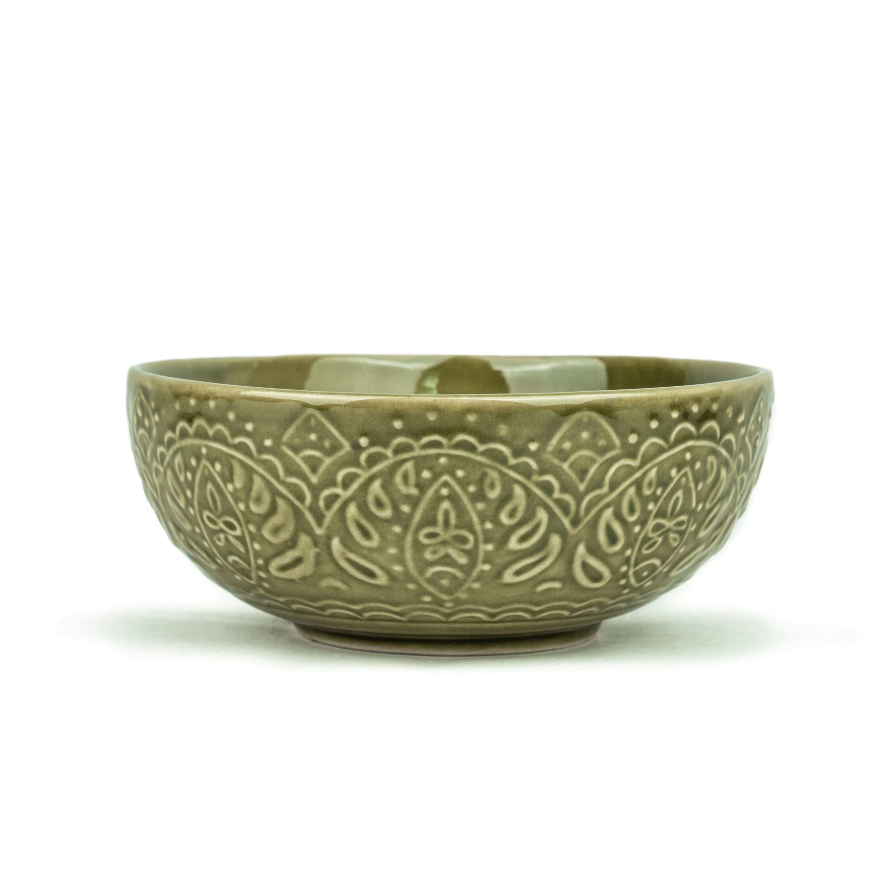 Green ceramic bowl with intricate patterns on a white background